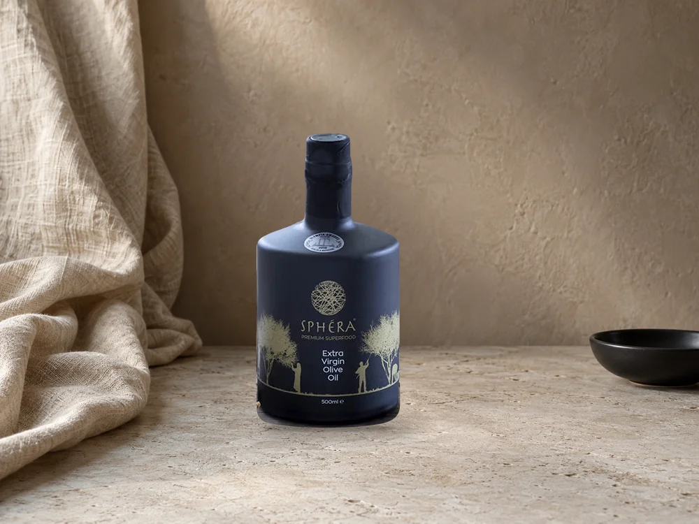 Draped linen, black ceramic bowl and warm plaster, with the authentic SPHERA bottle composited into an illustrative scene.