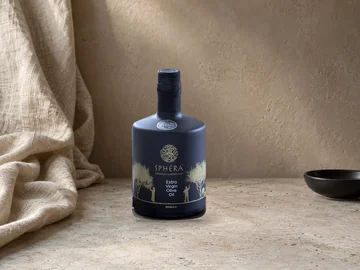 Draped linen, black ceramic bowl and warm plaster, with the authentic SPHERA bottle composited into an illustrative scene.